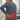 Woman with back pain holding her lower back in a living room setting.